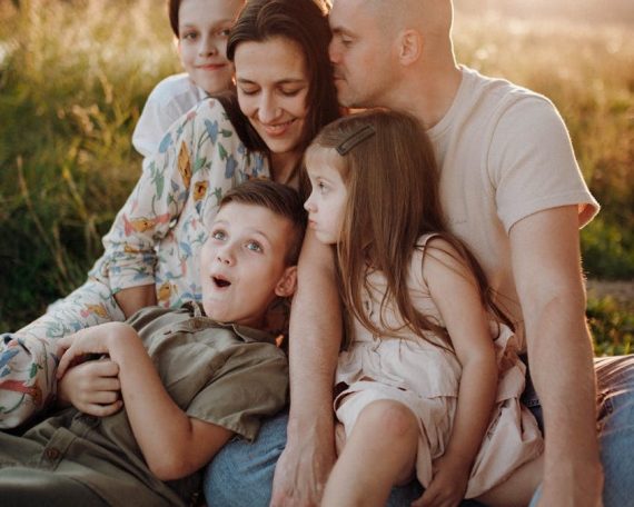 A joyful family enjoying quality time together on a sunset-lit meadow.
